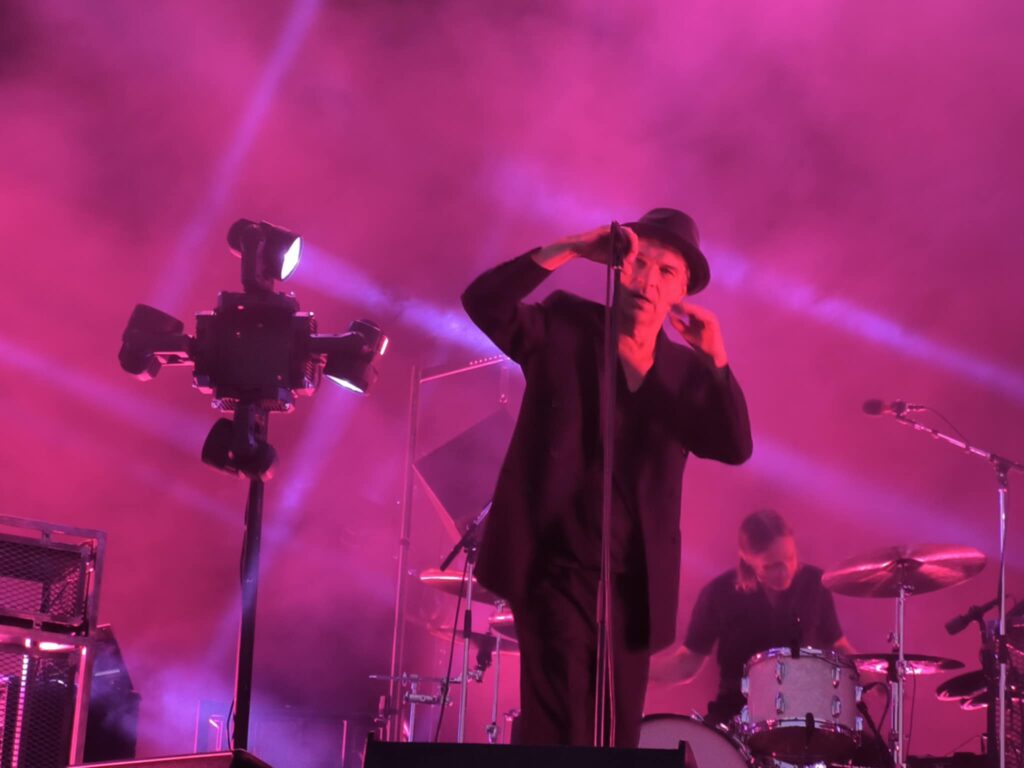 Thåström concert Karlstad – close-up of Thåström at the microphone with drummer in the background.