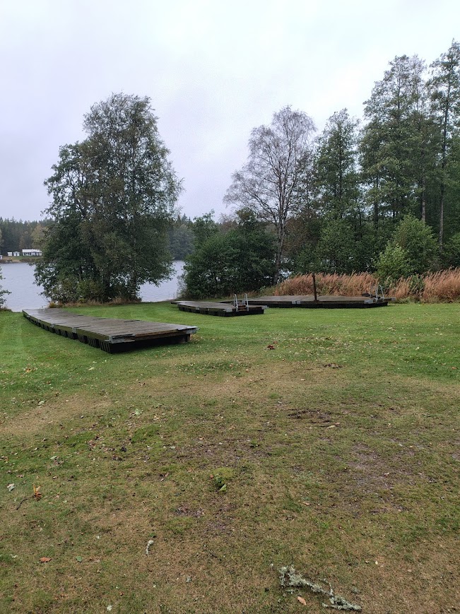 Träbryggor vid sjön en mulen morgon, där stillheten vilar och kroppen ropar efter lugn. En plats för vila, tystnad och eftertanke.