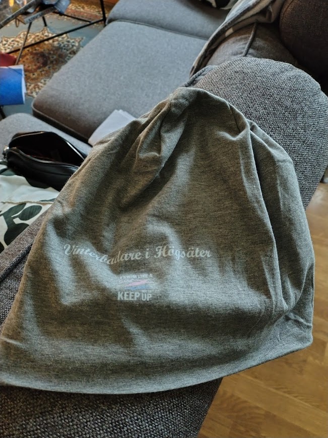 Grå badmössa med texten Vinterbadarna i Högsäter – symbol för gemenskap, styrka och etik och moral i vardagen.