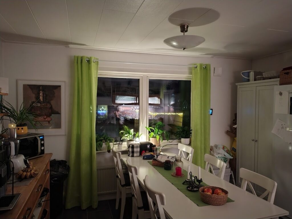 Köket efter julen är bortstädad – att längta efter våren, med limegröna gardiner, lugn stillhet och vardagsljus i rummet.