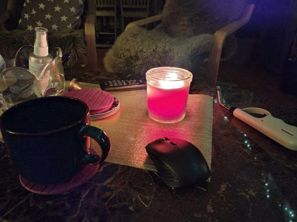 Morgonstund med levande ljus, kaffe och dator på bordet – en stillsam vardag där närvaro och tillit får ta plats.