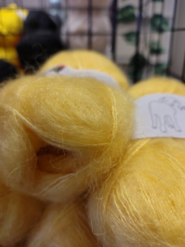 Mjukt, ljusgult mohairgarn i korg i garnaffären i byn.